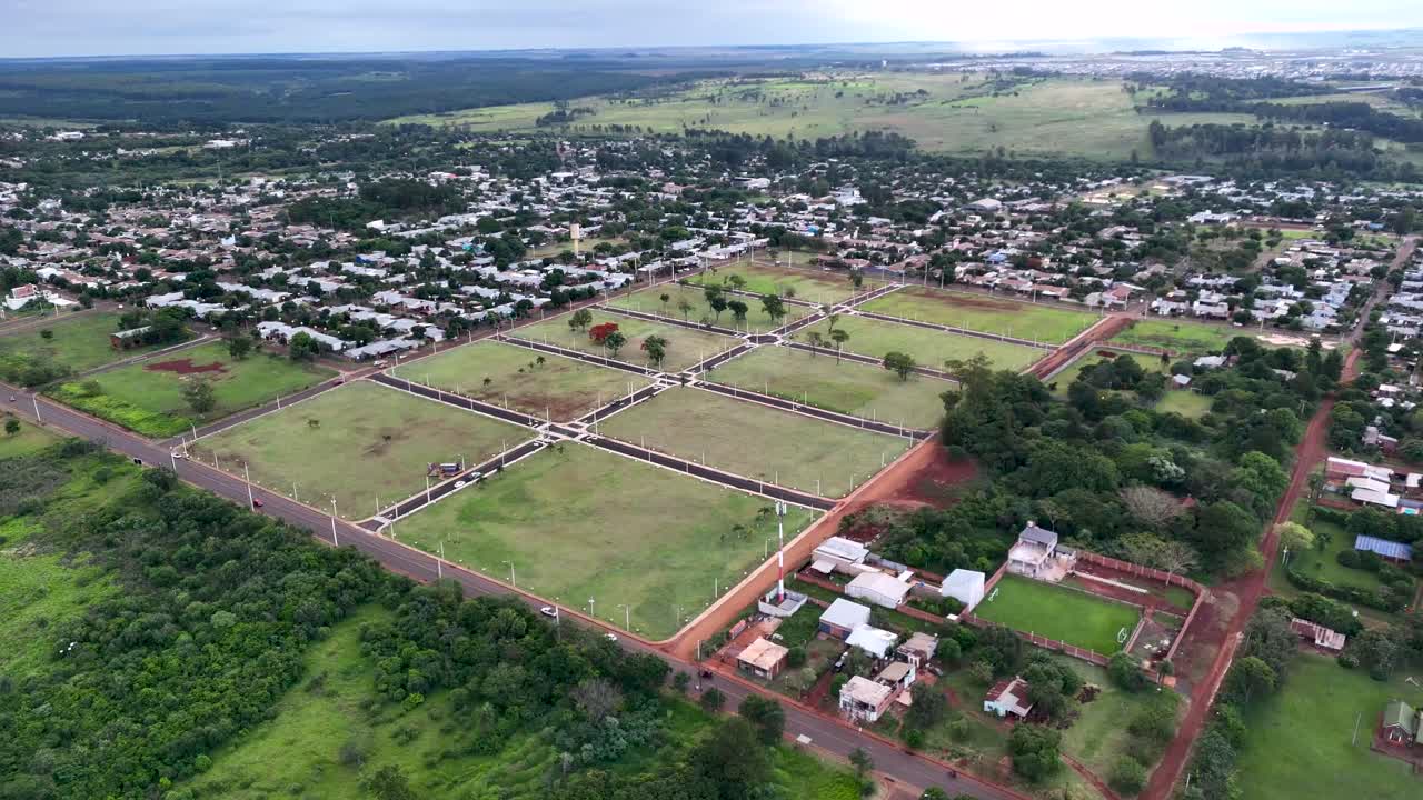 Aerial drone fly around a suburban neighborhood with housing lots ready for construction, Posadas, Misiones, Argentina