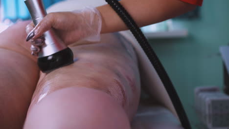 el cosmetólogo usa herramientas eléctricas para masajear a una chica gordita.