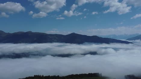 scenic aerial view of white clouds in a valley of the alps