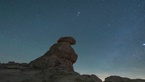 a panning right night timelapse of the starry sky across a rocky desert pinnacle foreground