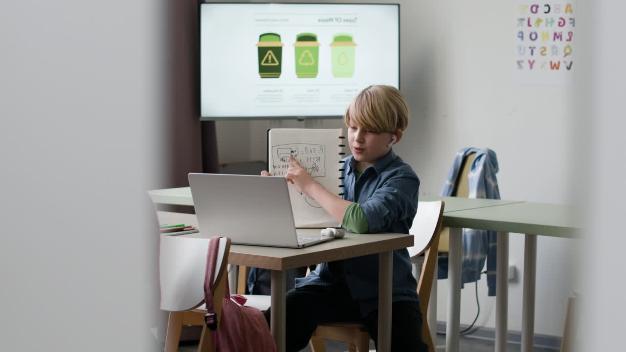 Student Engaging in Online Class with Notebook and Laptop