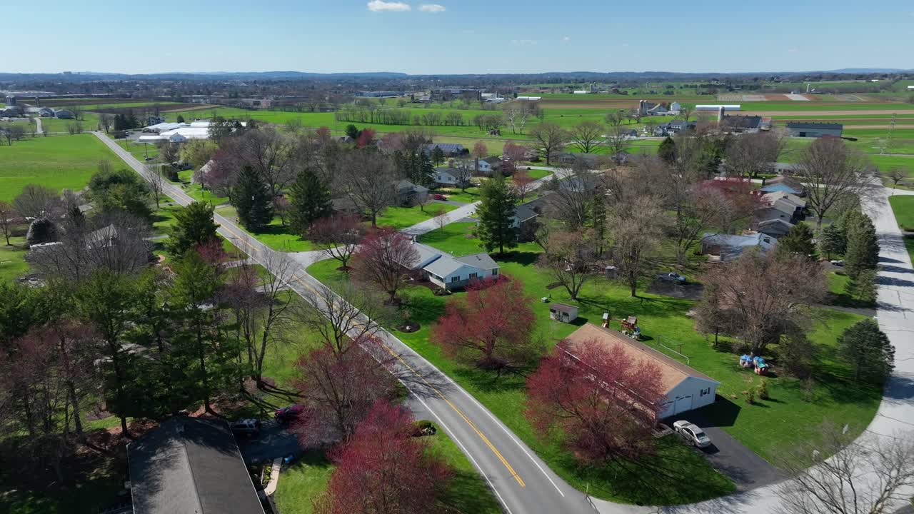 Pittoresco sobborgo verde degli USA con case unifamiliari illuminate dal sole in primavera