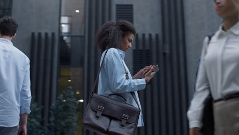 Focused-woman-using-tablet-computer-browsing-in-downtown.-Employees-go-to-office