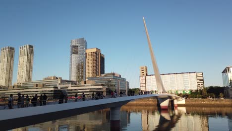 woman’s bridge in puerto madero, high rise skyline, travel landscape, sunset at buenos aires argentina