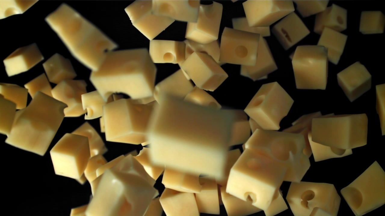 Cubetti di formaggio che cadono al rallentatore su sfondo nero