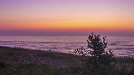 Sanfte-Wellen-An-Einem-Ruhigen-Strand-Während-Eines-Goldenen-Sonnenuntergangs-Mit-Hereinrollendem-Nebel---Zeitraffer