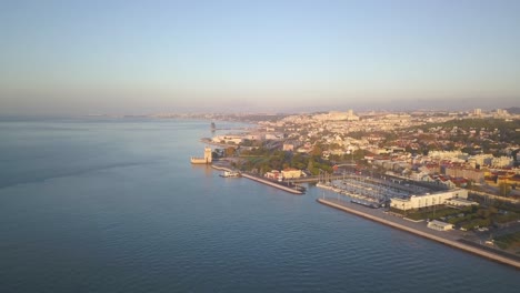 Turm-Von-Belem-In-Der-Nähe-Des-Denkmals-Der-Entdeckungen-Bei-Sonnenaufgang,-Lissabon,-Portugal,-Europa,-4K-Drohnenansicht-Aus-Der-Luft