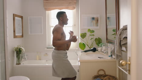 happy-african-american-man-dancing-shirtless-in-bathroom-looking-in-mirror-having-fun-morning-routine-getting-ready-enjoying-positive-self-image-doing-silly-dance-celebrating-success