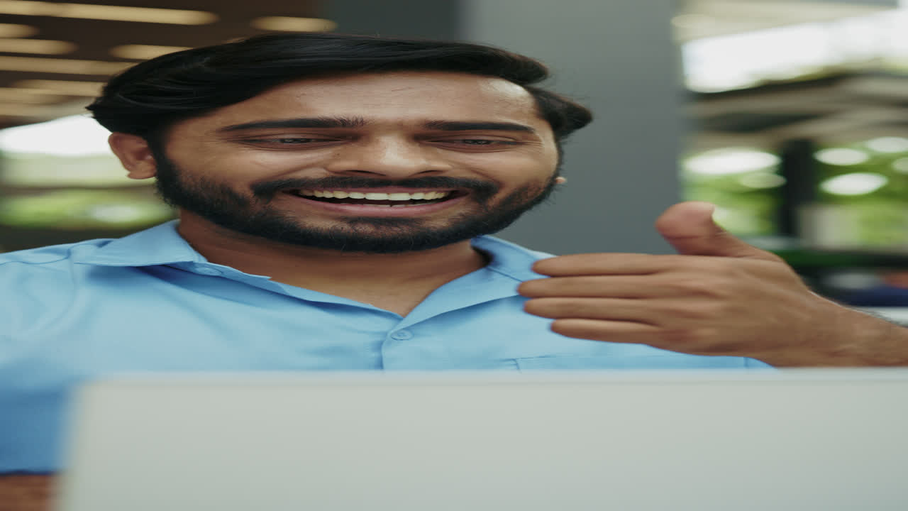 hombre indio feliz trabajando en computadora portátil