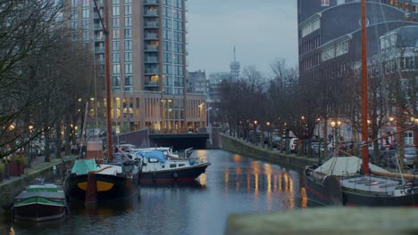 Paisaje-Cinematográfico-Vista-Nocturna-De-La-Ciudad-De-La-Haya-O-Den-Haag-Con-Luces,-Calles,-Casas,-Canales,-Agua-Y-Barcos-En-El-Auténtico-Estilo-De-Arquitectura-Tradicional-Europea-De-Los-Países-Bajos-Holandeses.