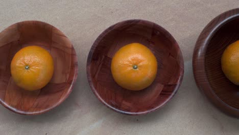 orange in wooden bolws pan left to right