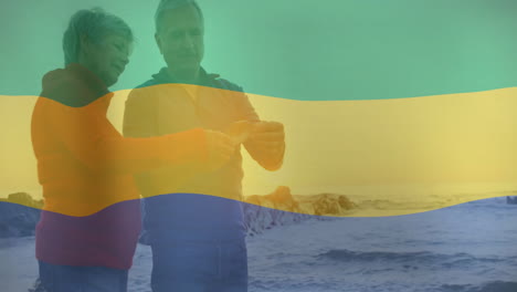 on beach, elderly couple walking along shore with colorful wave animation overlay
