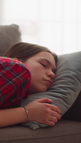 pretty tired young woman in casual garment sleeps on comfortable sofa with soft pillow at home closeup slow motion. calm lady relaxes at cozy place to rest