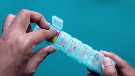 hands using a weekly pill organizer