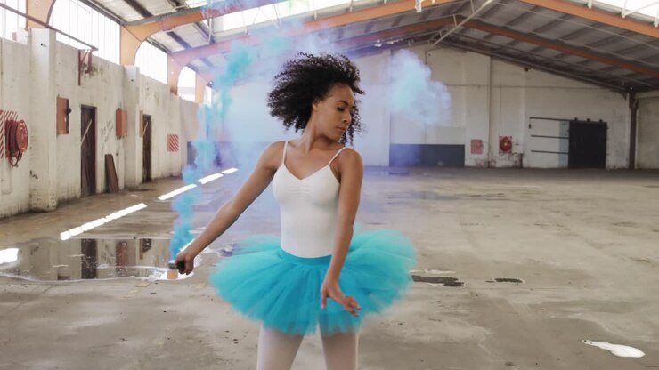 Female dancer in an empty warehouse holding smoke grenade