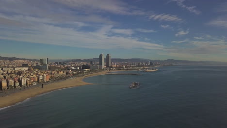 Forwards-fly-along-sea-coast.-Sand-beaches-and-buildings-along-coast-in-travel-destination.-Barcelona,-Spain