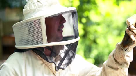 beekeeper holding a bottle of honey