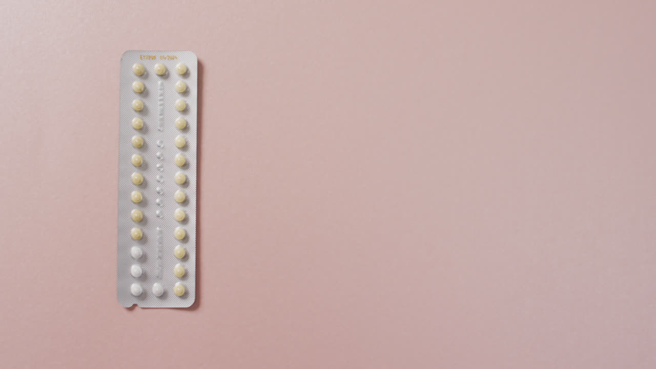Video of close up of yellow tablets on pink background