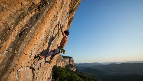 a man rock climbing on a steep cliff face under a clear sky
