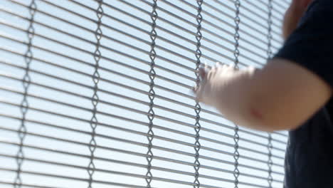 close up of kid running hands on a metal fence