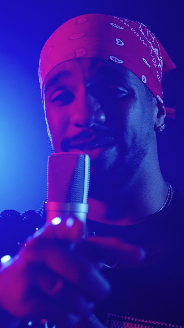 Man singing into a microphone with a bandana