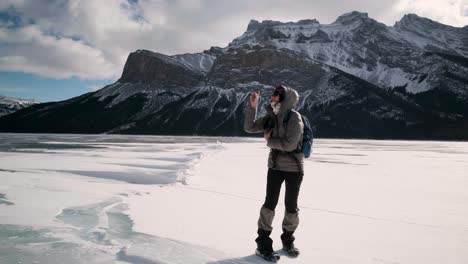 Mädchen-In-Winterwanderausrüstung-Macht-Ein-VR-360-Foto-Auf-Einem-Zugefrorenen-See