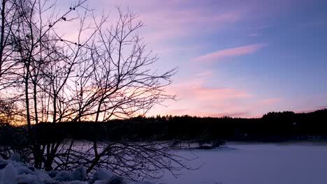 A-light-mist-rises-over-a-frozen-lake-during-sunset-as-planes-cross-the-darkening-sky