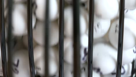 extreme close-up of numbered balls spinning in a lottery or bingo drum