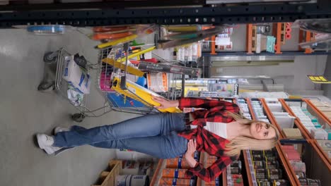 a beautiful blonde in a red shirt in a hardware store she sincerely laughs at the camera