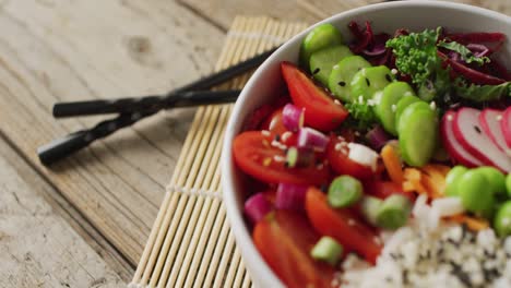 Composición-Del-Plato-De-Arroz-Y-Verduras-Con-Palillos-Sobre-Fondo-De-Madera.