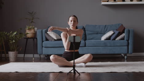 young influencer recording a yoga lesson with her smartphone