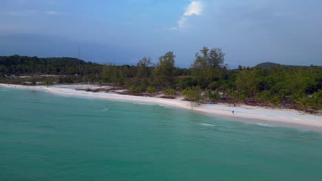turquoise waves crashing on the white sandy sok san beach in koh rong island, cambodia, at sunset. gorgeous aerial view flight panorama orbit drone
