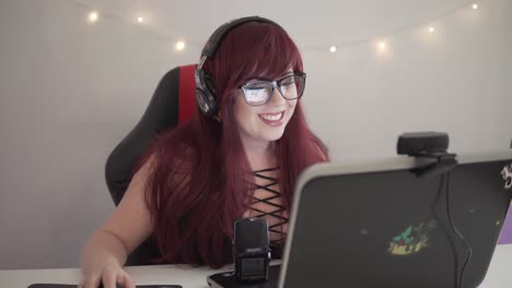 Young-streamer-girl-with-red-hair-is-playing-games-while-being-live-on-youtube-or-twitch
