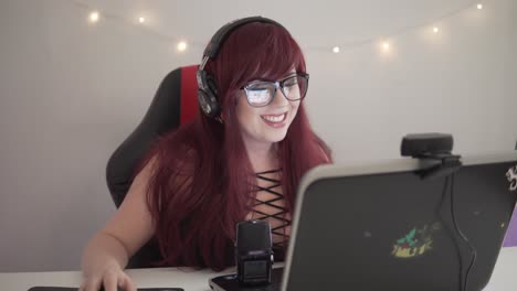 young streamer girl with red hair is playing games while being live on youtube or twitch