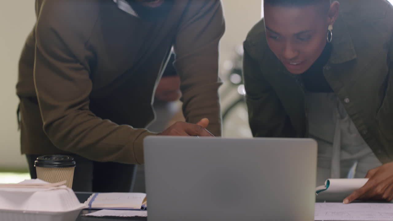 professional black business people using laptop creative team leader businessman sharing ideas collaborating with colleagues pointing at screen in office close up