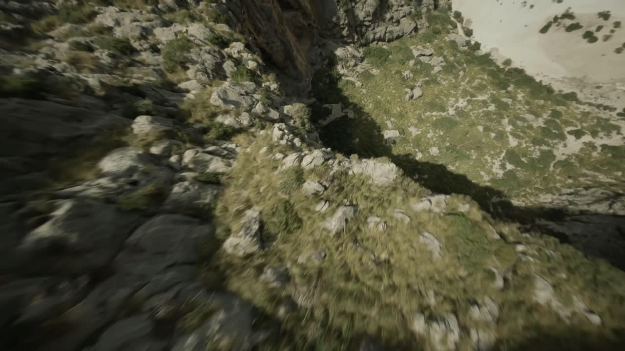 drone fpv disparado sobre torrent de pareis a lo largo de la cordillera rocosa en la bahía de sa calobra, mallorca, españa en un día soleado