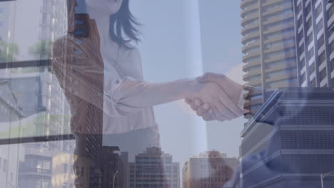 animation of cityscape over diverse business people shaking hands