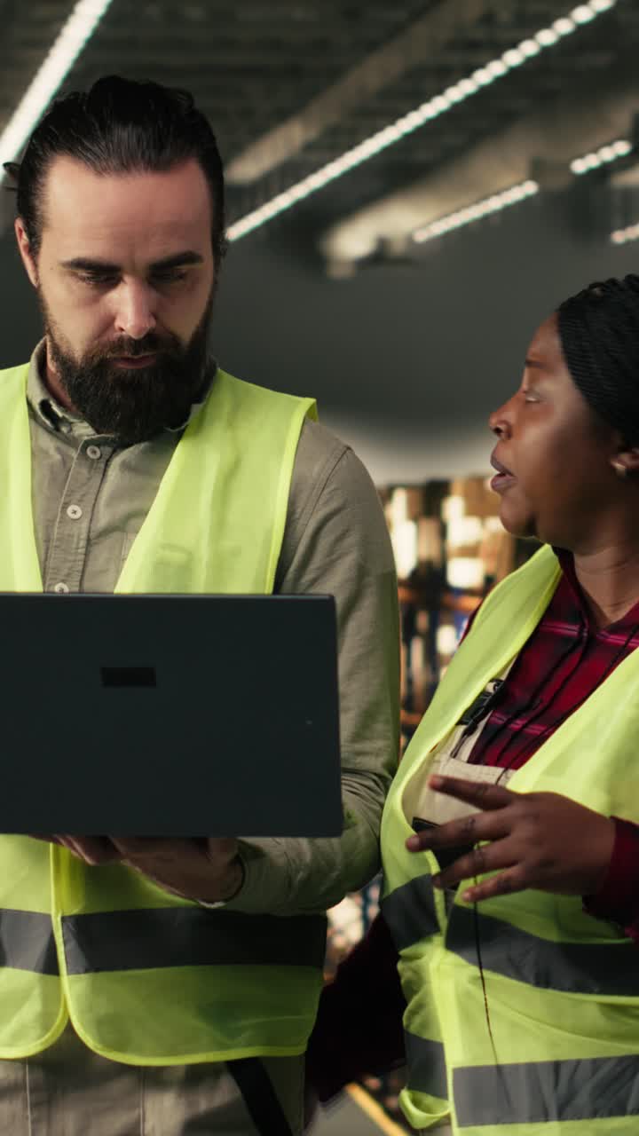 Vertical Video Multiethnic employees managing warehouse operations on laptop software