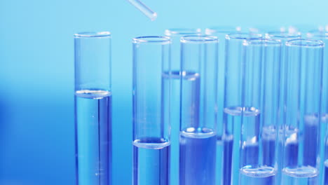 Video-of-laboratory-pipette-and-test-tubes-with-copy-space-on-blue-background