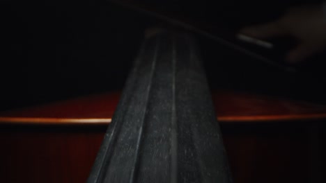 slow motion artistic macro of master artisan luthier playing with a bow on a handmade violin or cello. shot in 8k. concept of spiritual instrument, art, orchestra, passion for music, sound, pre