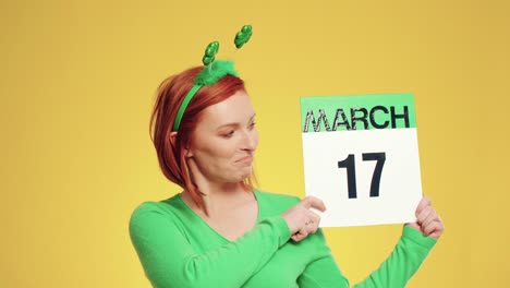 Woman showing calendar with a date for Saint Patrick&#039;s Day