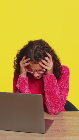 Girl using laptop surprised by bad news fortune loss game fail lottery results sitting at table