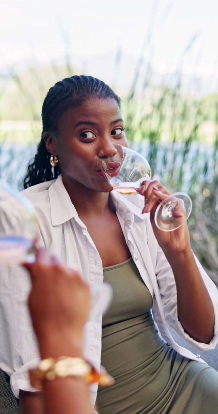 Young Woman Laughing and Drinking Wine with Friend Outdoors