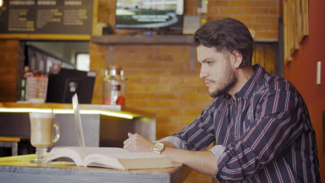 handsome guy using laptop on a coffee shop