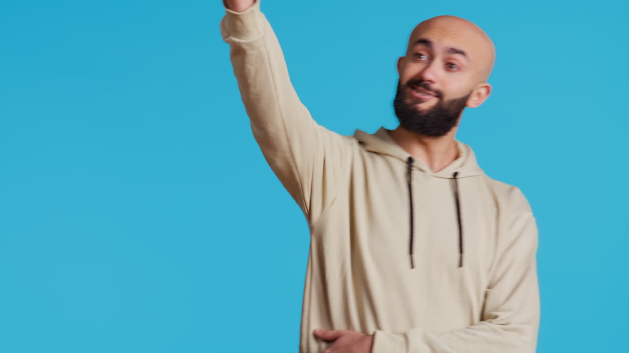 Uomo arabo che saluta una persona mentre posa in studio