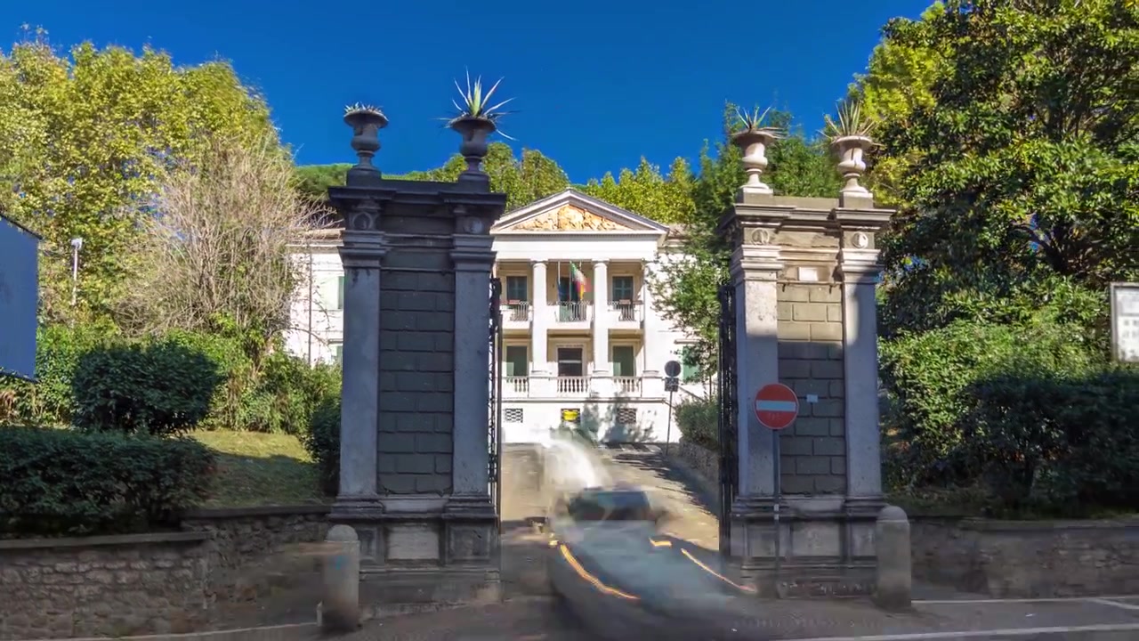 Timelapse Hyperlapse della vista frontale del Museo di Villa Ferrajoli con cancelli nella pittoresca Albano Laziale, Italia. Museo storico tra il traffico su affascinanti strade cittadine.