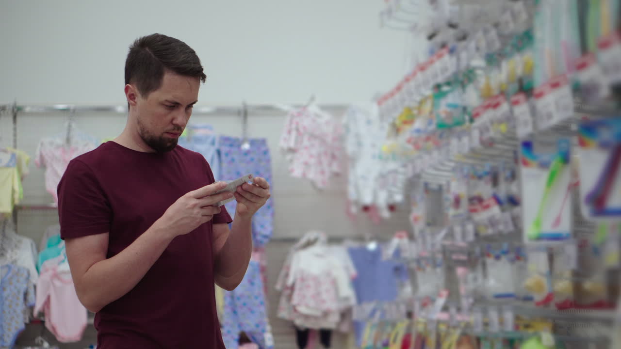 hombre comprando ropa para bebés en una tienda