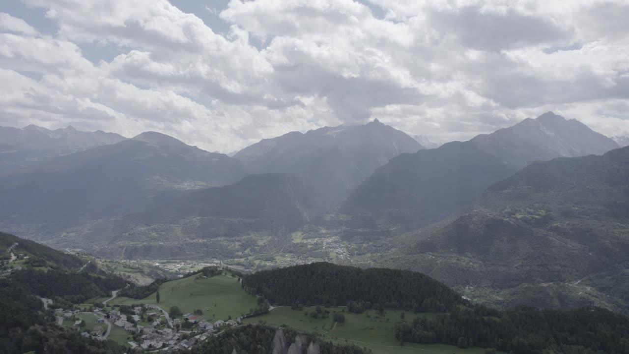 avión avanzando con drones sobre el valle de aosta en san nicolas con la iglesia de fonfo y sobre un camino sinuoso