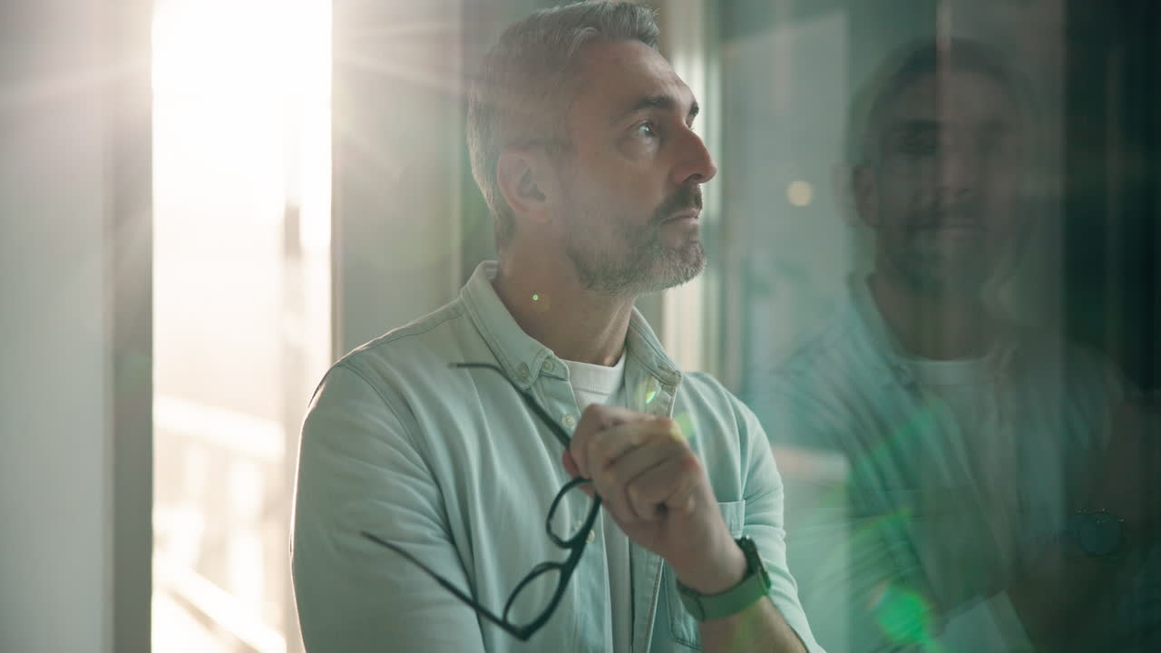 Man looking out of window with reflection