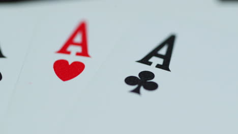 macro detail shot of top of playing cards with all four aces hearths diamonds space cross lying on an elephant while moving as the cards slowly expose from the side